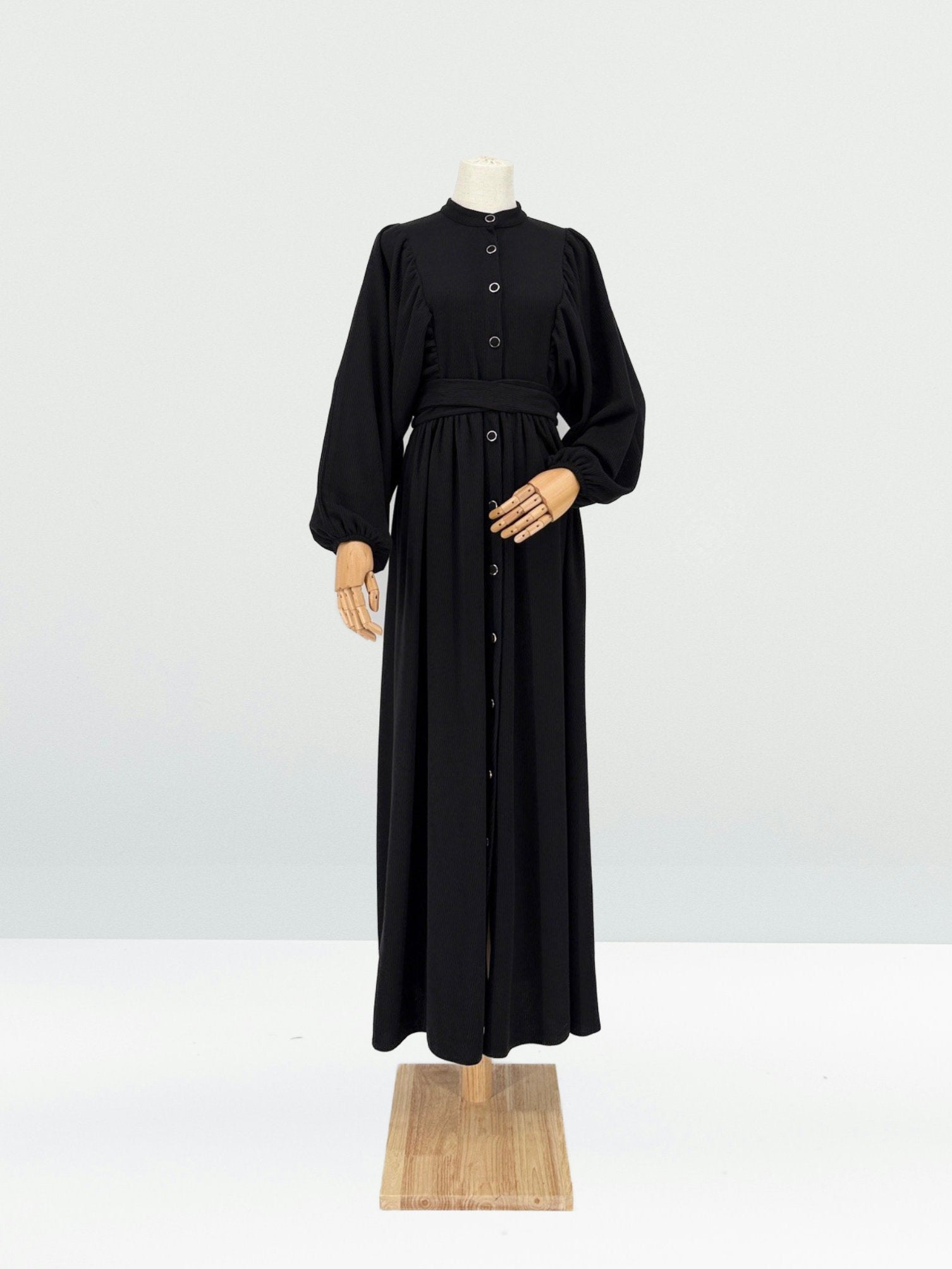 Black ribbed knit dress on a mannequin against a white background