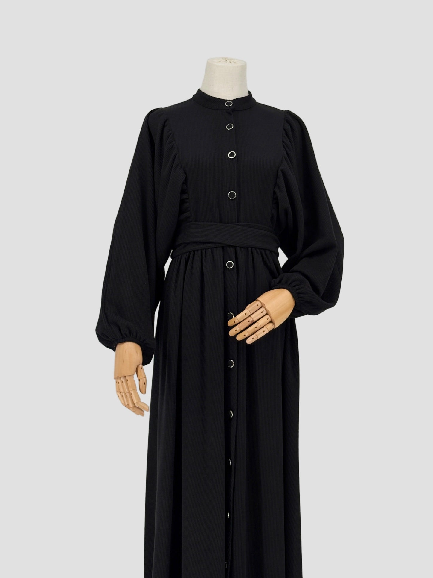 Black ribbed knit dress on a mannequin against a white background