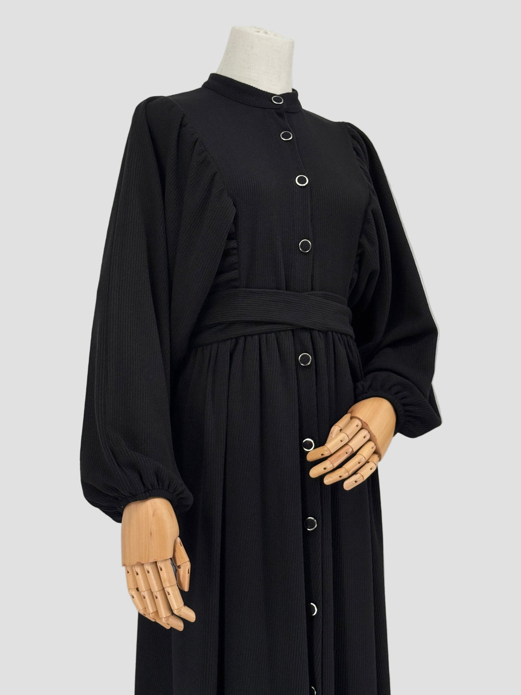 Black ribbed knit dress on a mannequin against a white background