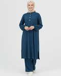 Woman wearing a blue ribbed matching set with a hijab on a white background