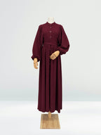 Maroon ribbed knit dress on a mannequin against a white background