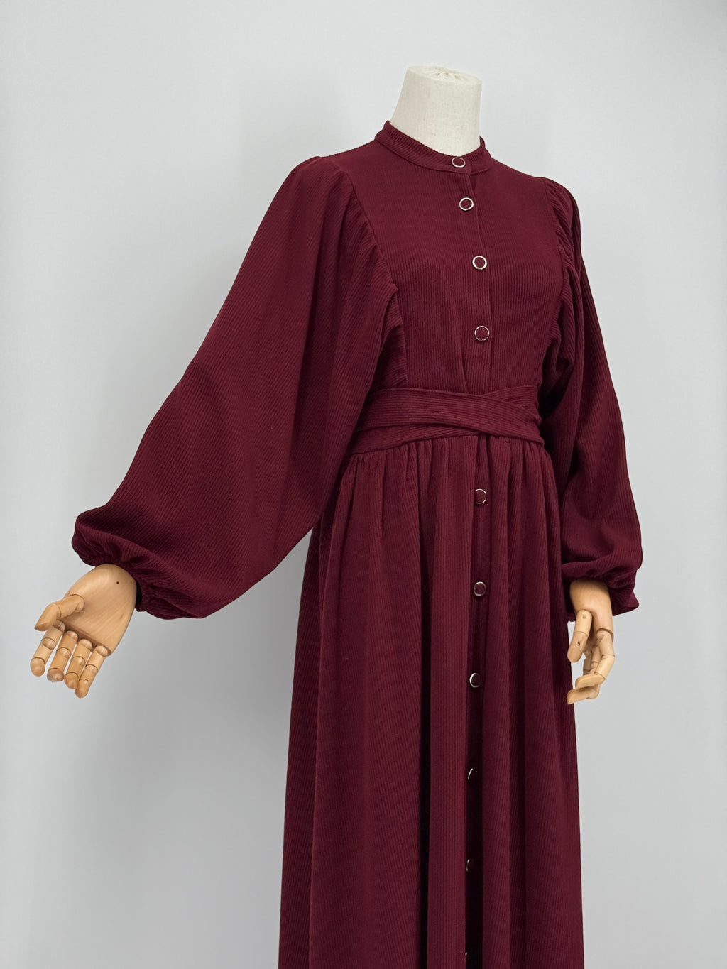 Maroon ribbed knit dress on a mannequin against a white background