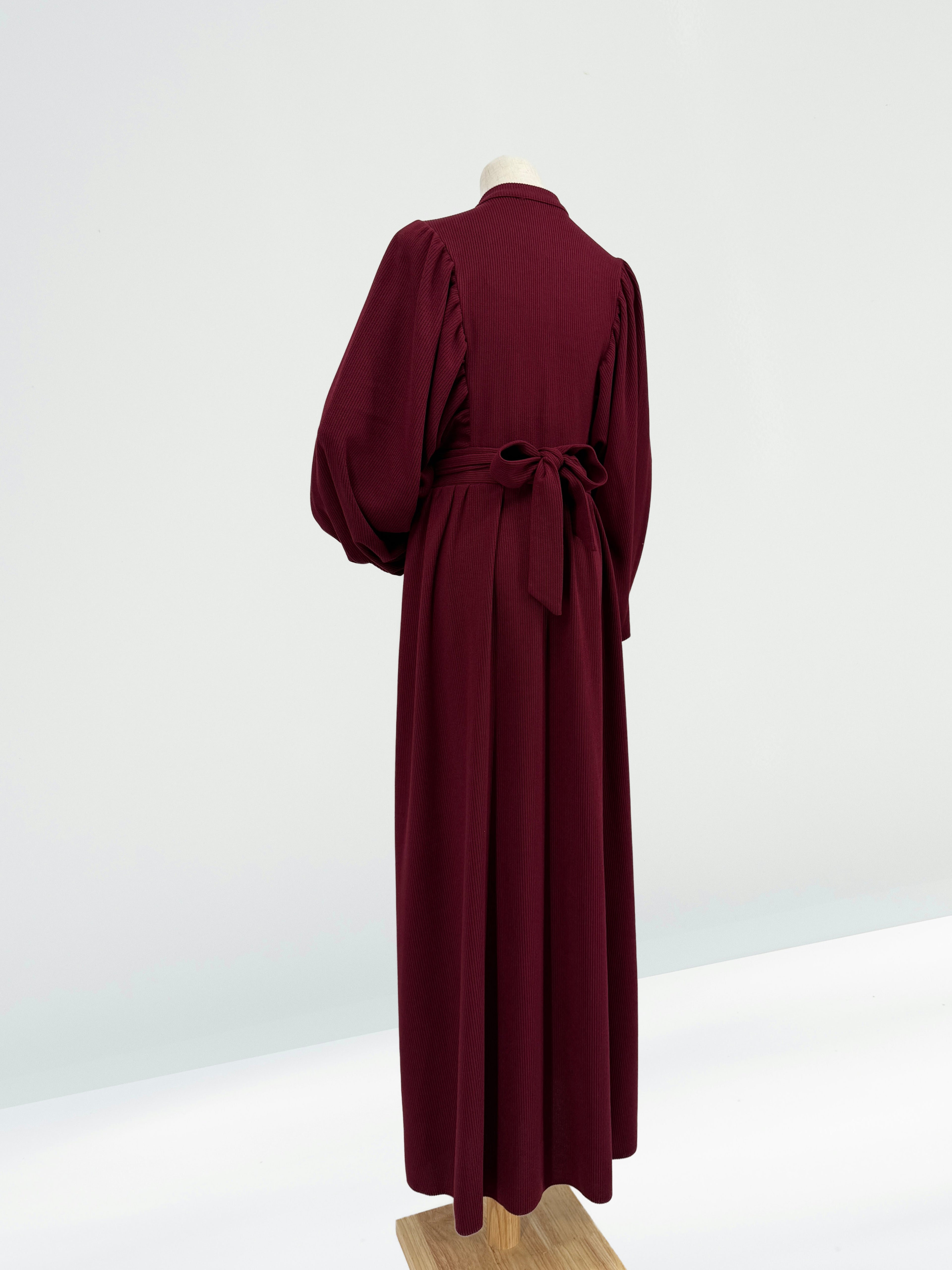 Maroon ribbed knit dress on a mannequin against a white background