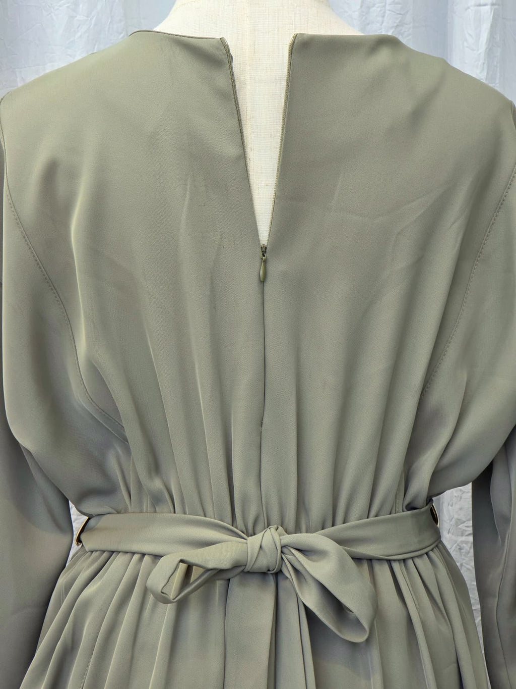 Light green dress with a belt on a mannequin against a light background