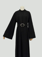 black abaya dress with a belt on a mannequin against a white background