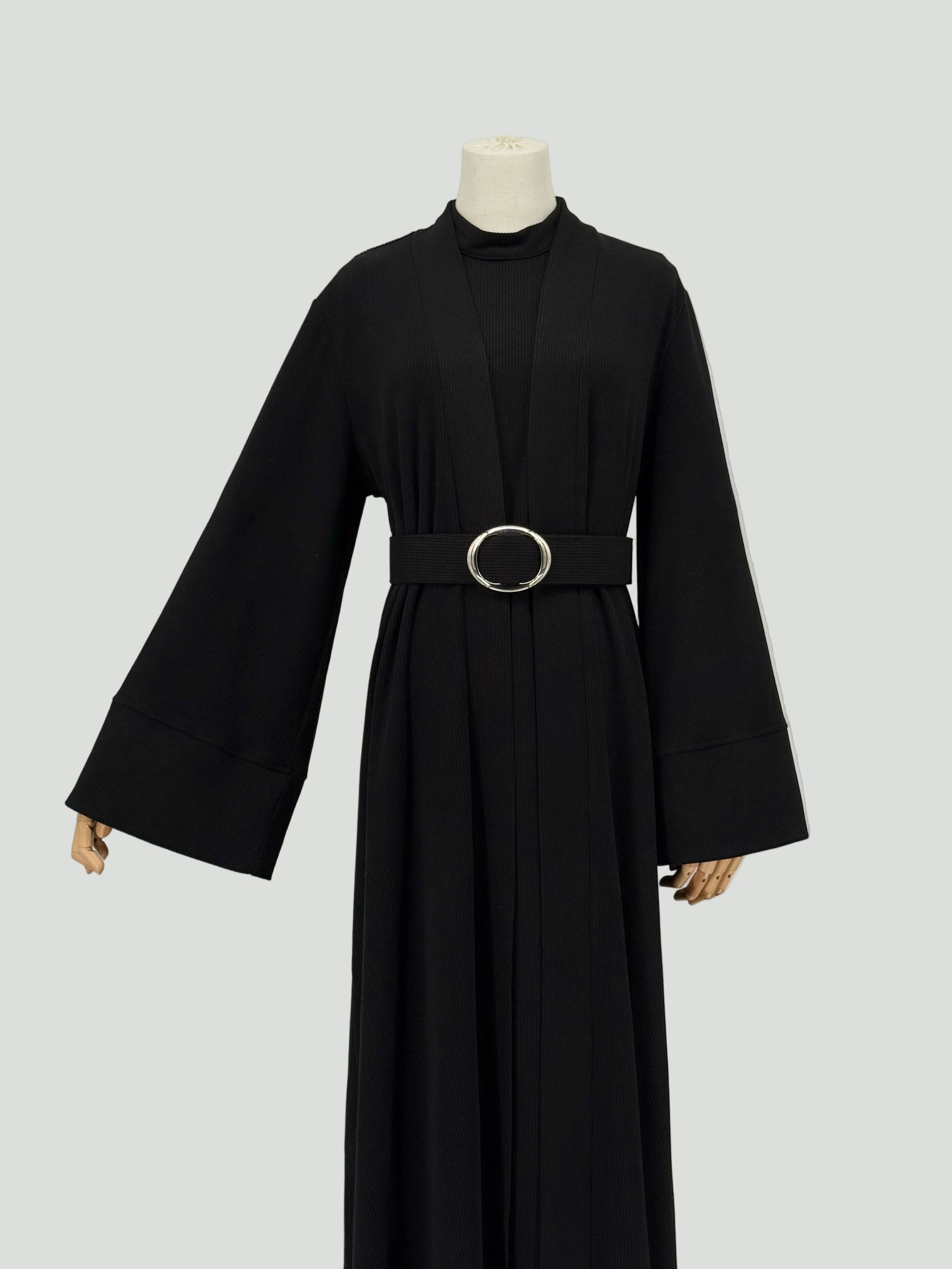 black abaya dress with a belt on a mannequin against a white background