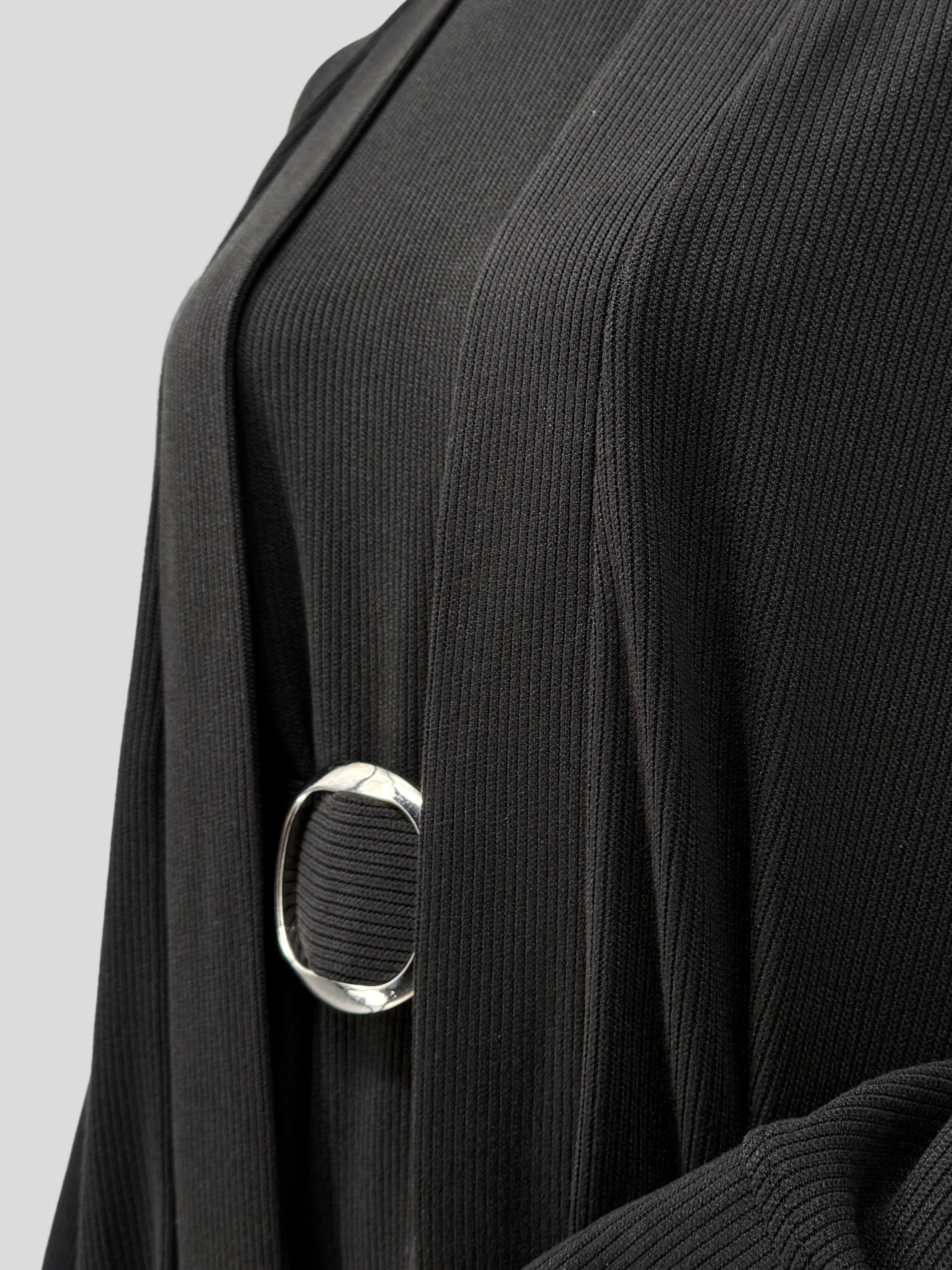 Close-up of a black ribbed abaya dress with a silver belt on a white background