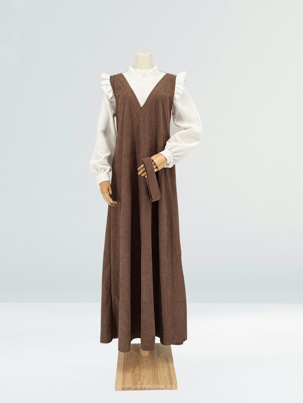 Brown and white dress on a mannequin against a light gray background