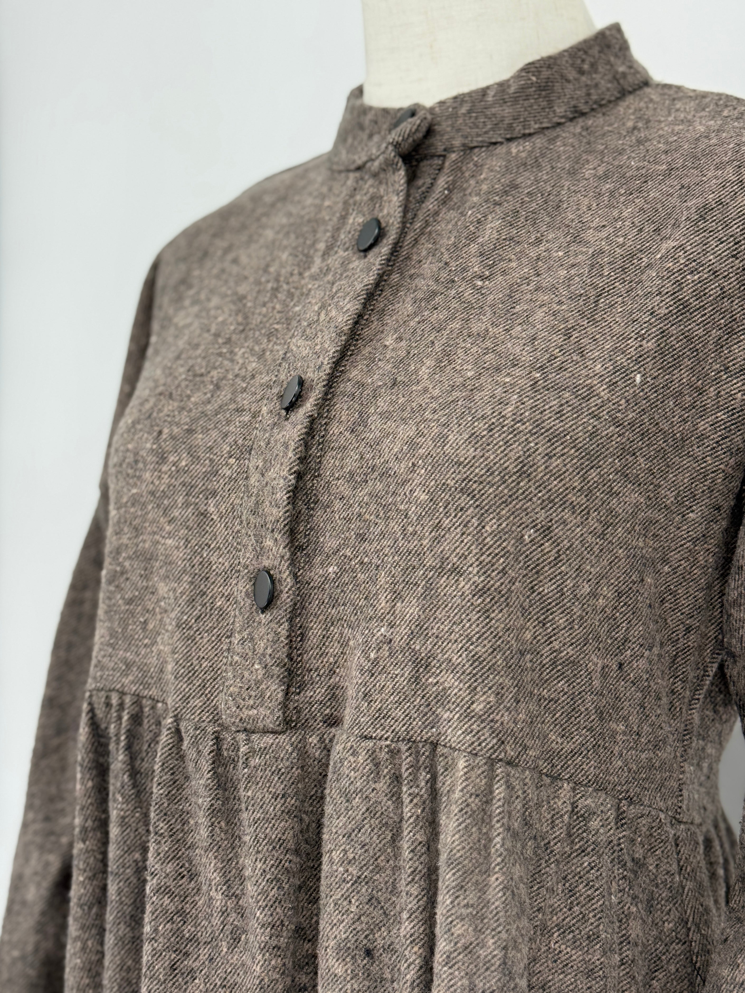 close-up on a brown long-sleeve dress on a mannequin against a white background