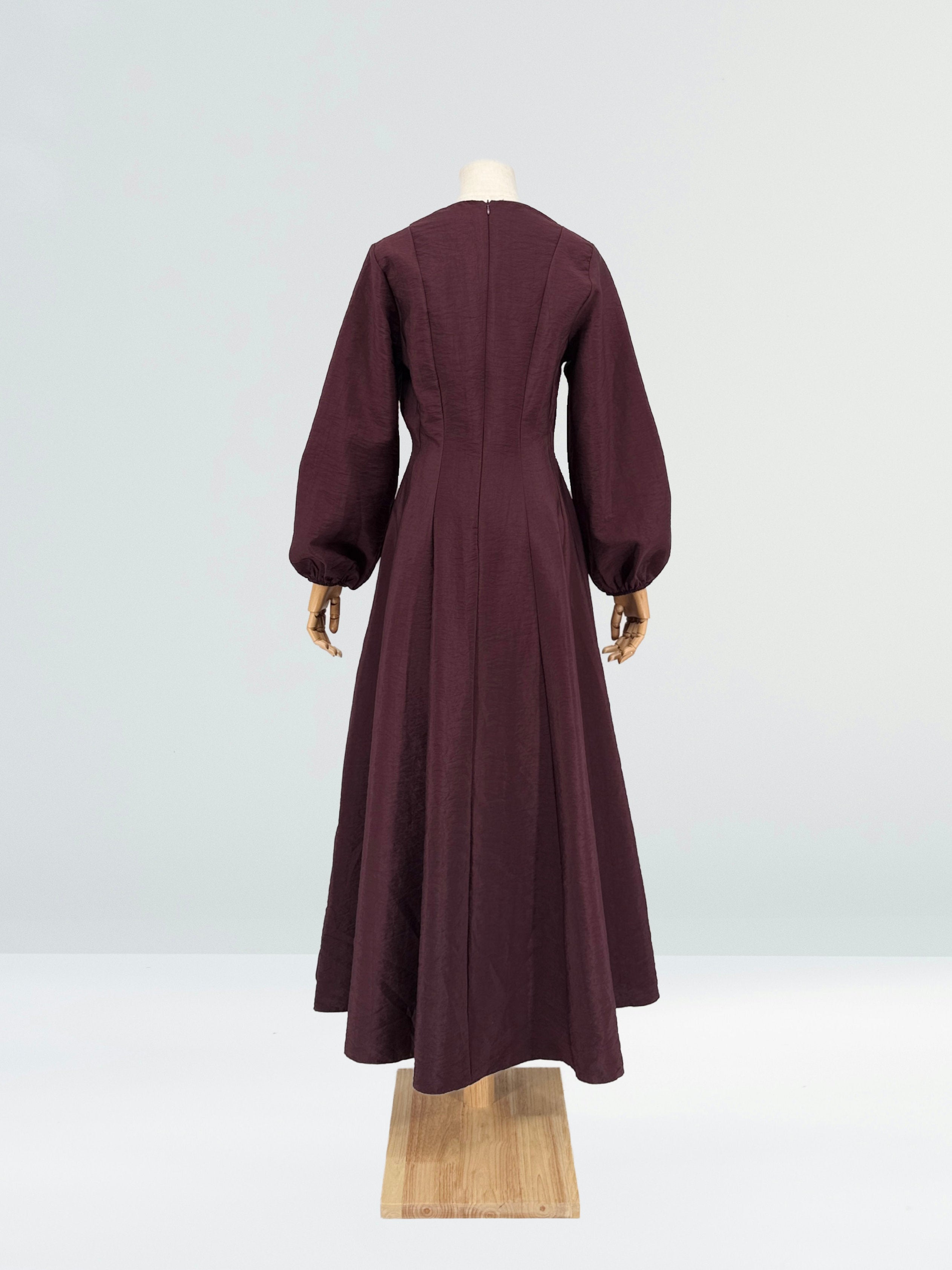 Burgundy flare dress on a mannequin against a plain background