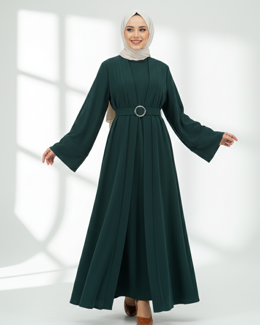 Woman wearing a dark green abaya dress with long sleeves on a white background