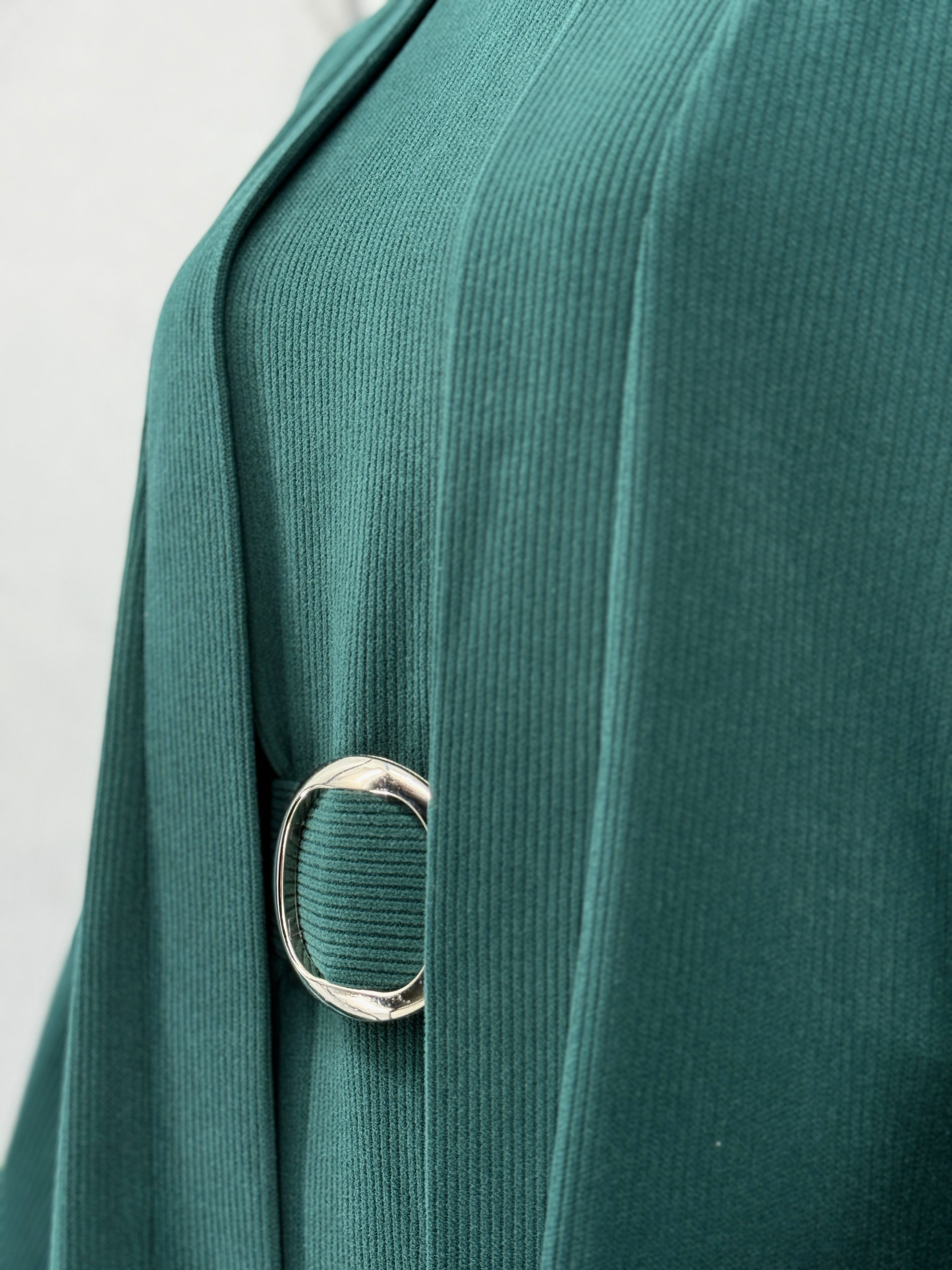 Close-up of a dark green rib-knit abaya with a silver ring belt on a white background