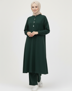 Woman wearing a dark green ribbed set with buttons on a white background