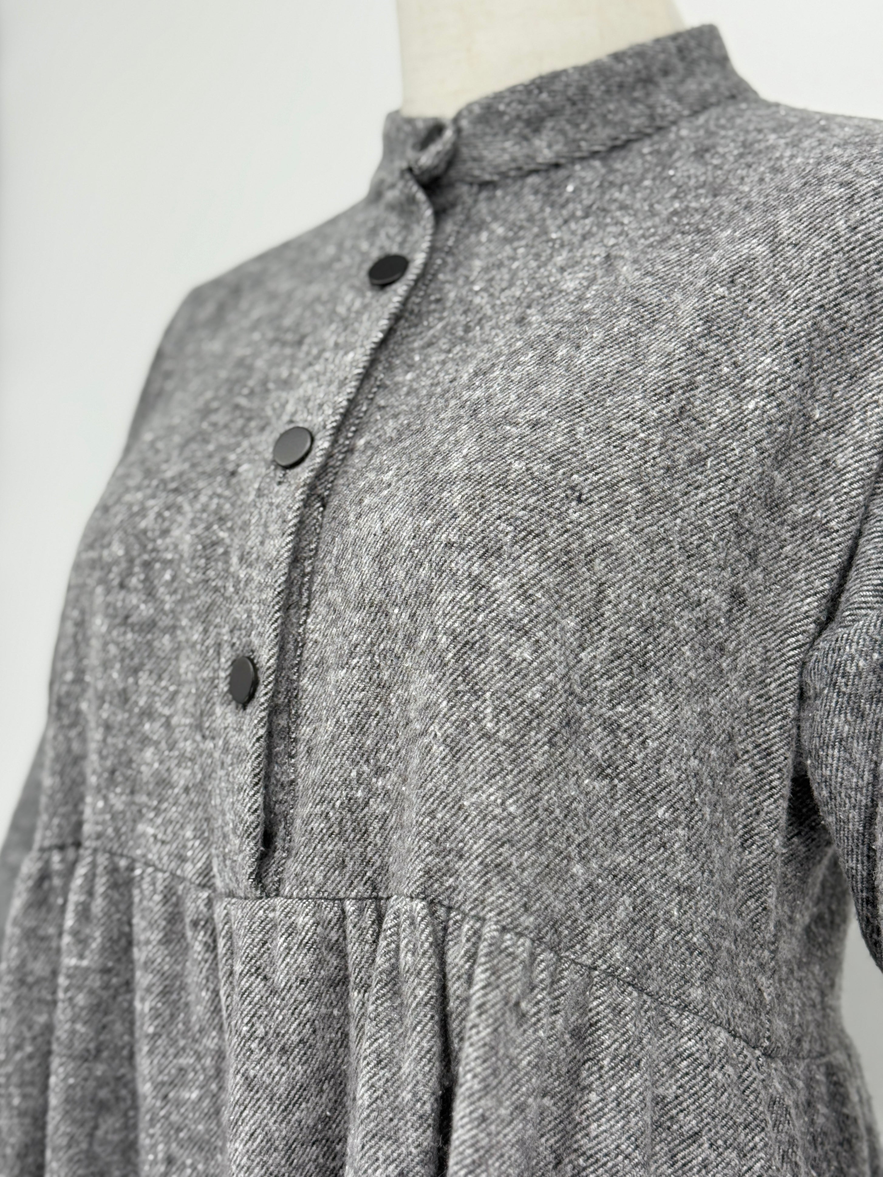 close-up on gray long-sleeve dress on a mannequin against a white background