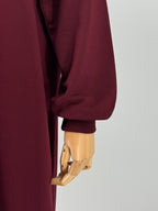 close-up of a maroon long-sleeve tunic on a mannequin against a white background