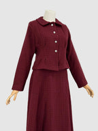 Burgundy tweed suit on a mannequin against a plain background