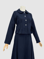 Navy blue tweed suit on a mannequin against a plain background