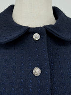 close-up of navy blue tweed suit on a mannequin against a plain background