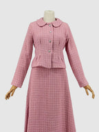 Pink tweed suit on a mannequin against a plain background