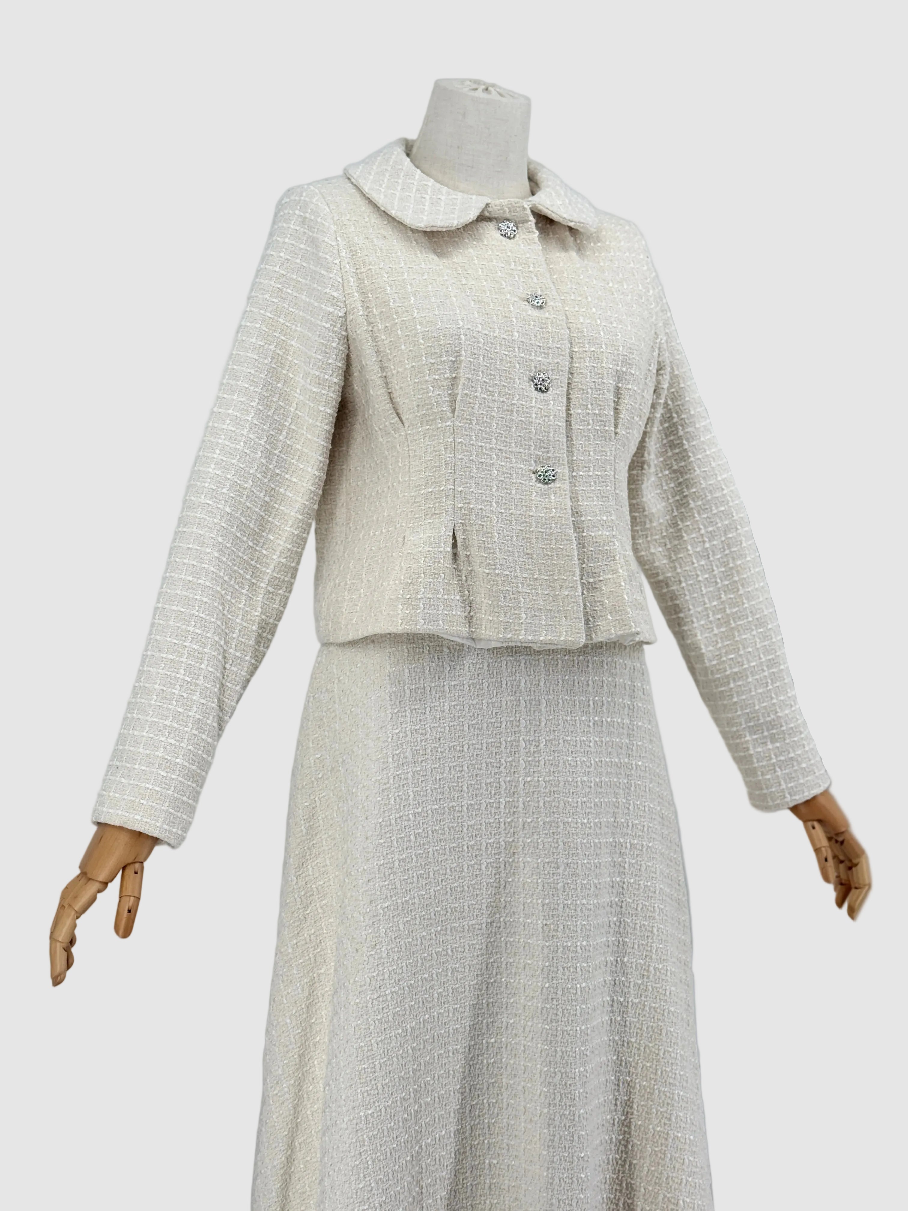 Off-white tweed suit on a mannequin against a plain background